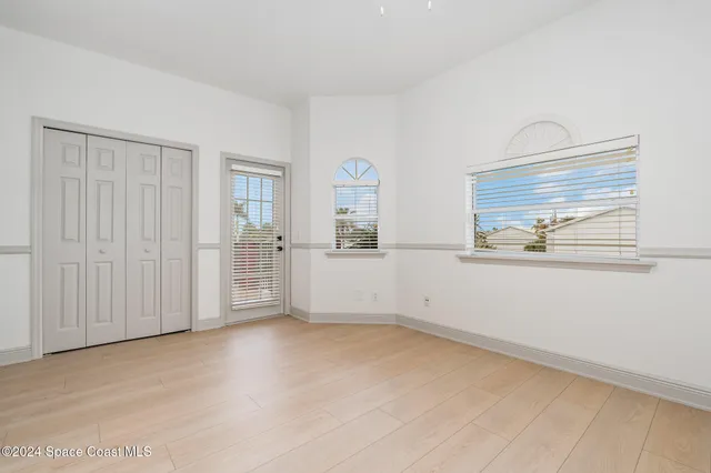 an empty room with windows and wardrobe