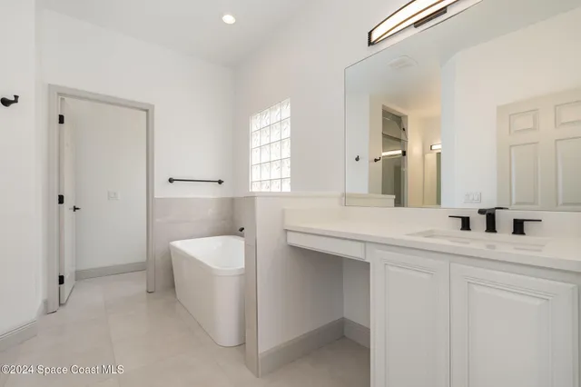 a spacious bathroom with a granite countertop sink and a mirror