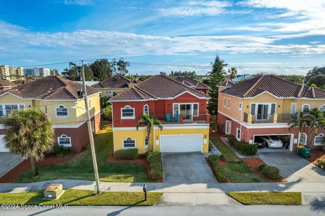 a front view of multiple houses with yard