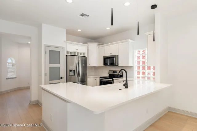 a kitchen with kitchen island a sink stainless steel appliances and cabinets