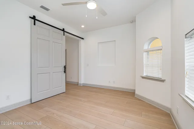 an empty room with windows and closet