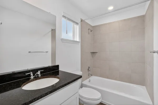 a bathroom with a granite countertop sink toilet a mirror and shower