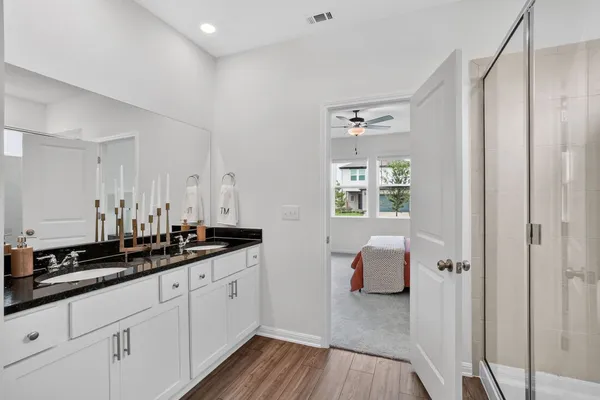 a en suite bathroom with a granite countertop sink and a mirror