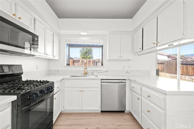 a kitchen with white cabinets and appliances