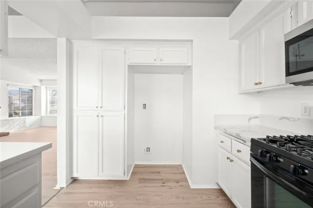 a kitchen with white cabinets and black appliances