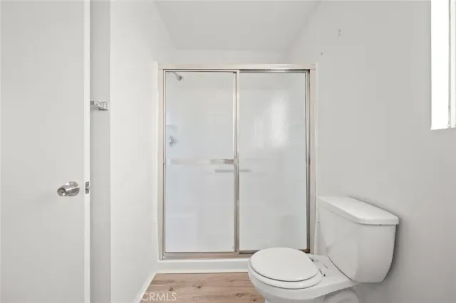a white toilet sitting next to a shower