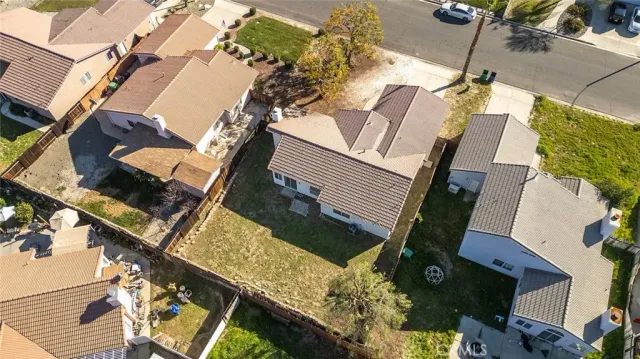 an aerial view of a house with a yard and parking