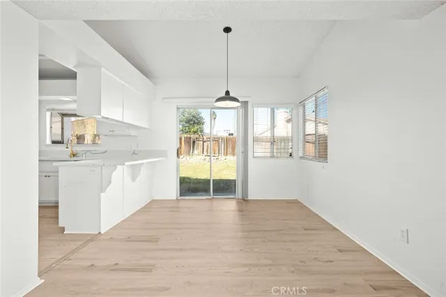 a view of a kitchen with kitchen island a sink wooden floor and a chandelier