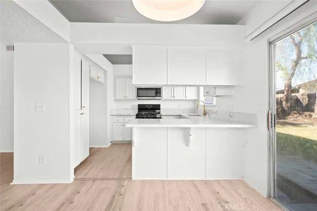 a kitchen with stainless steel appliances granite countertop a refrigerator sink and white cabinets