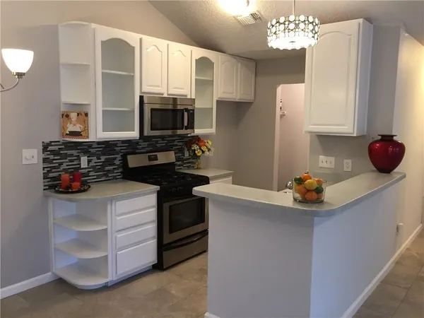 a kitchen with stainless steel appliances a stove refrigerator and microwave