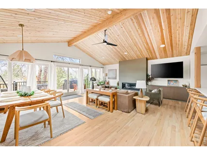 a living room with furniture a flat screen tv and a large window