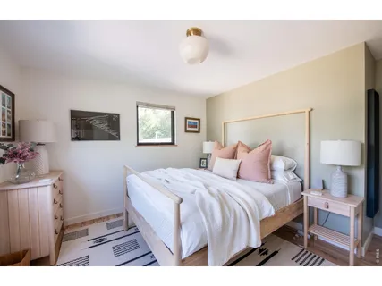 a bedroom with a bed and a lamp on dresser