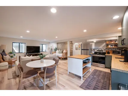 a living room with furniture a flat screen tv and kitchen view