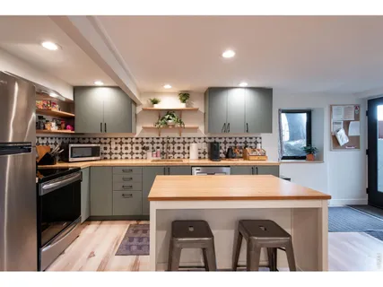 a kitchen with a sink a stove and chairs