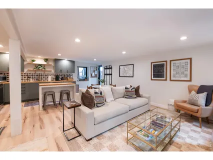a living room with furniture and a view of kitchen