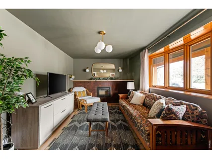 a living room with furniture a chandelier and a flat screen tv