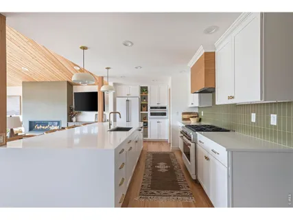 a large kitchen with stainless steel appliances kitchen island granite countertop a sink and cabinets
