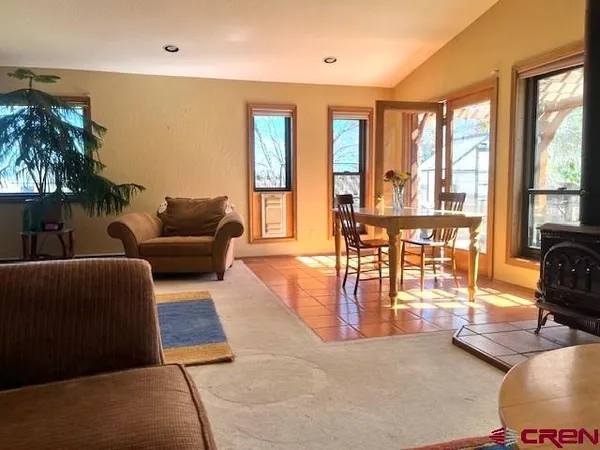 a kitchen with stainless steel appliances granite countertop a table chairs and a refrigerator