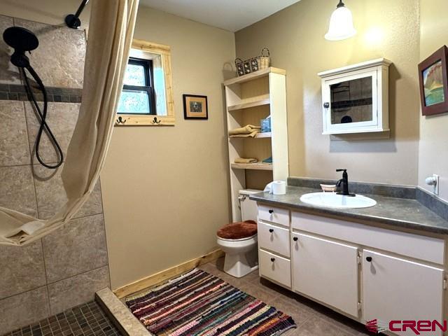 921 North Market Street Cortez, CO 81321 - Photo 27 of 45 a bathroom with a granite countertop sink toilet and shower