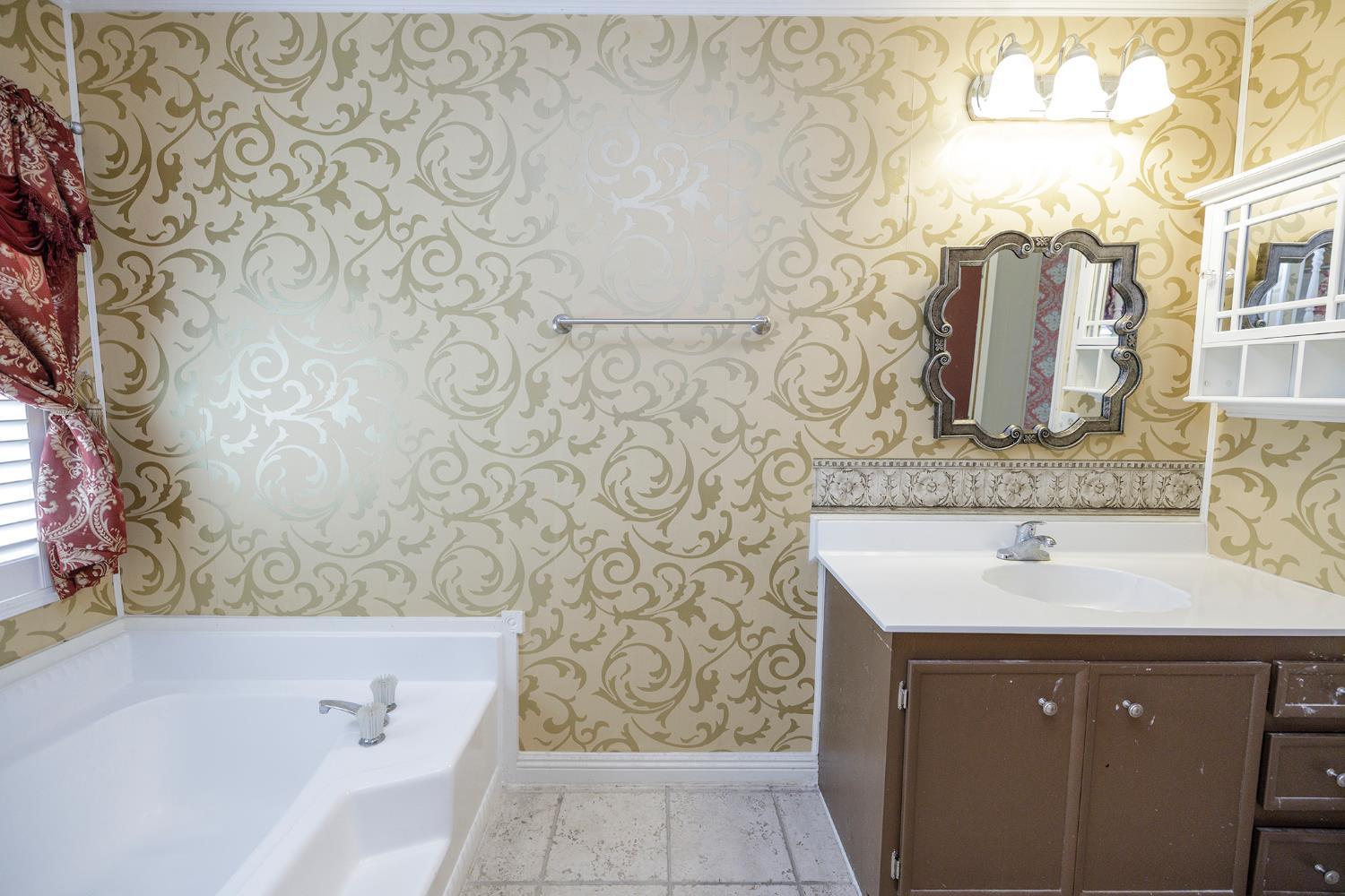 3924 Lahaina Lane Modesto, CA 95355 - Photo 25 of 32 a bathroom with a sink and mirror with bathtub