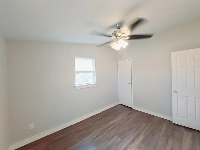 a view of a room with wooden floor and a ceiling fan