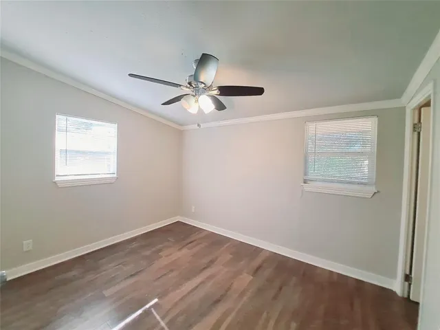 a view of a room with wooden floor and a ceiling fan