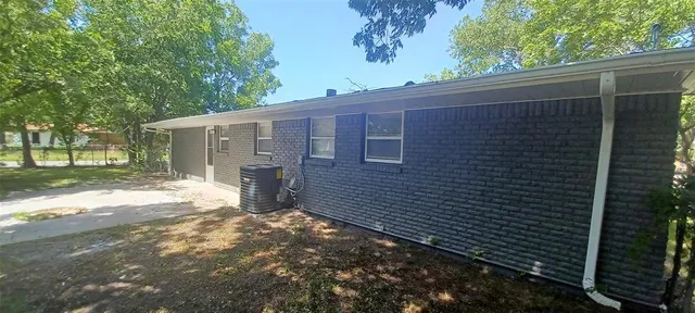 a view of a backyard with brick wall and plants