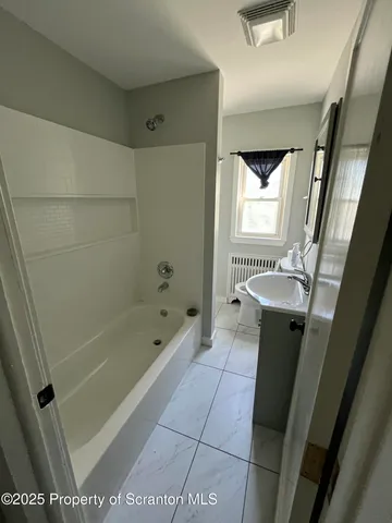 a bathroom with a sink a toilet a mirror and a tub