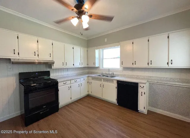 a kitchen with stainless steel appliances granite countertop a stove a sink and white cabinets