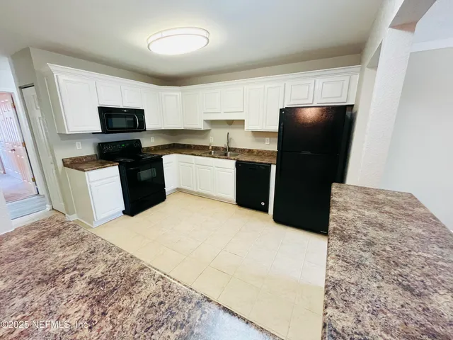 a kitchen with a refrigerator and a stove top oven