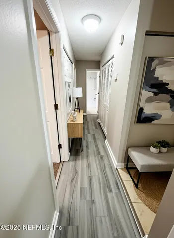 a view of a hallway with wooden floor and staircase