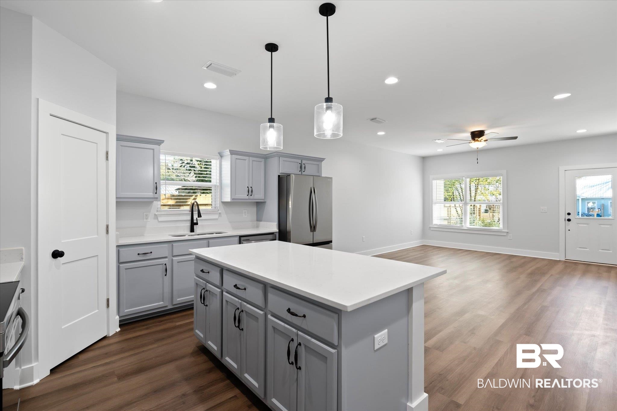 18151 Hoiles Street Robertsdale, AL 36567 - Photo 6 of 23 Kitchen featuring a center island, sink, hanging light fixtures, stainless steel refrigerator, and gray cabinetry