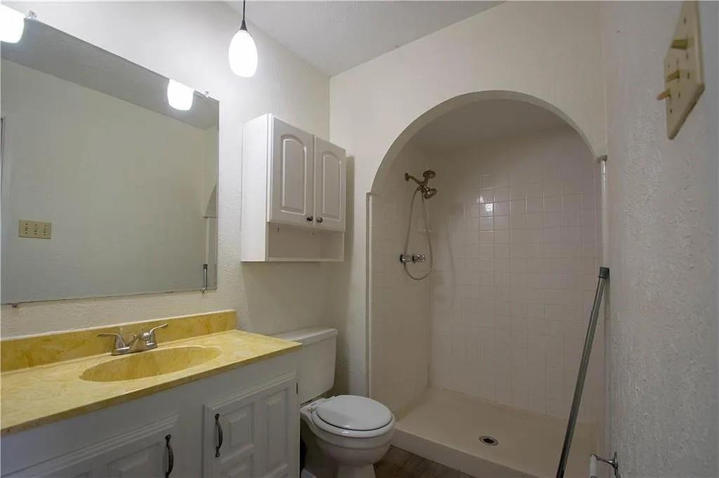 6500 Blue Ridge Trail Plano, TX 75023 - Photo 12 of 14 Bathroom featuring a vanity with a yellow-toned countertop and integrated sink, white cabinetry below, and a wall-mounted mirror