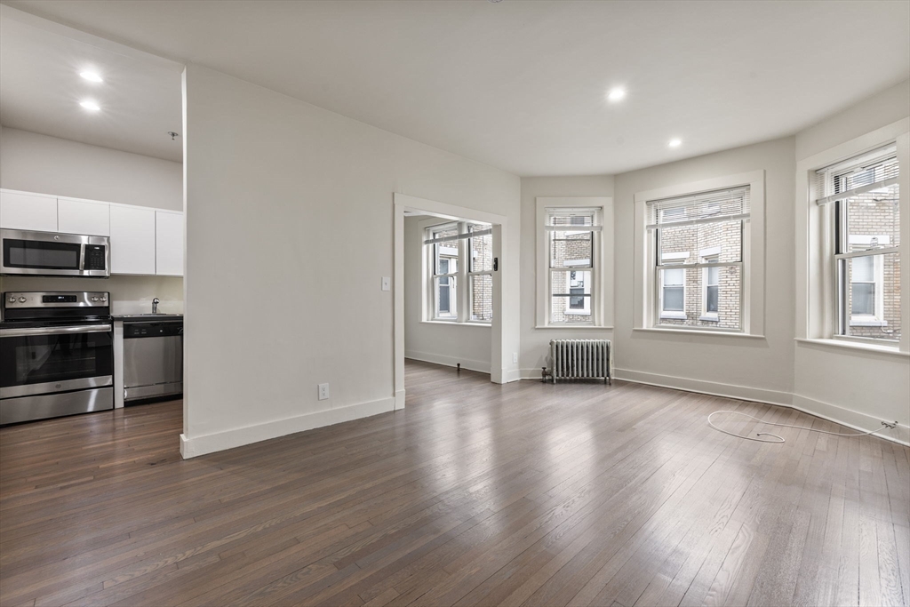 74 Fenway, Unit 45 Boston, MA 02115 - Photo 1 of 12 an empty room with wooden floor and windows