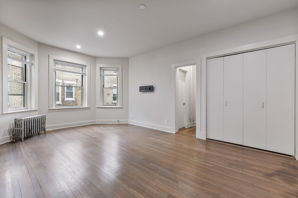 74 Fenway, Unit 45 Boston, MA 02115 - Photo 5 of 12 an empty room with wooden floor and windows