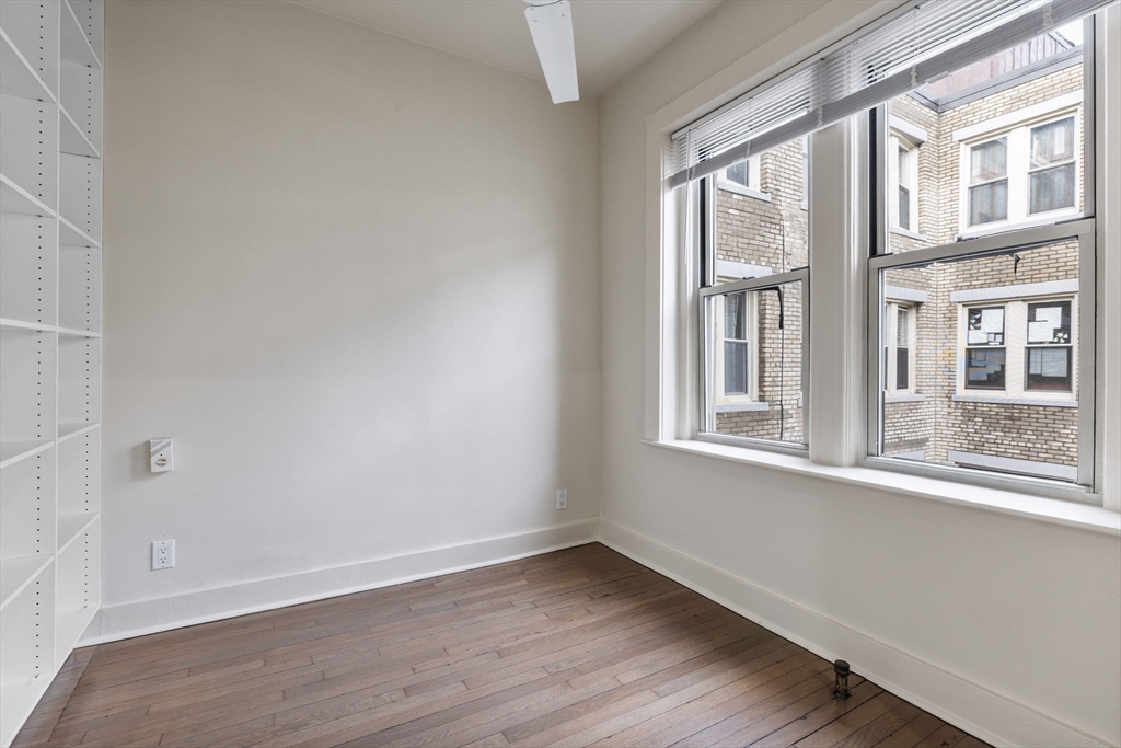 74 Fenway, Unit 45 Boston, MA 02115 - Photo 7 of 12 an empty room with wooden floor and windows