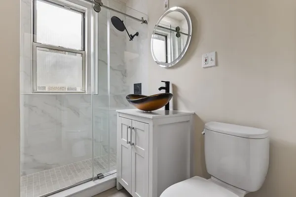 a bathroom with a toilet a sink and a mirror
