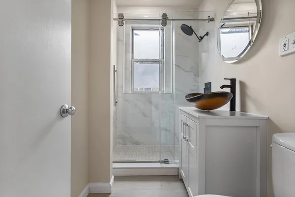 a bathroom with a sink a toilet and shower