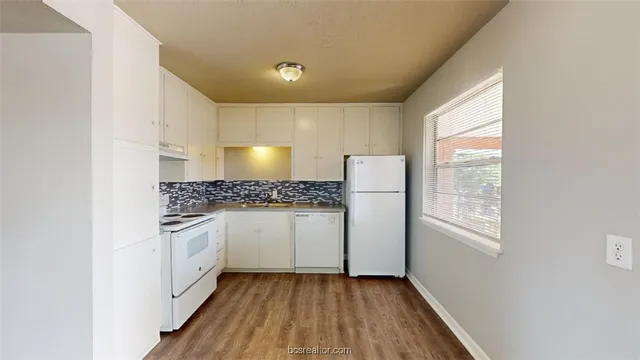 a kitchen with granite countertop white cabinets and white appliances