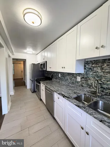 a kitchen with stainless steel appliances granite countertop a sink and cabinets