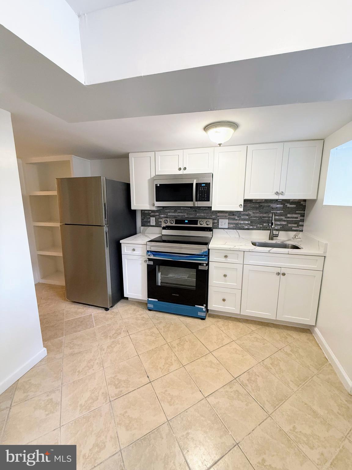 1714 E Street Northeast Washington, DC 20002 - Photo 28 of 30 a kitchen with granite countertop a stove a sink and a refrigerator