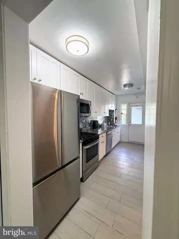 a kitchen with stainless steel appliances granite countertop a refrigerator a stove a sink and a microwave