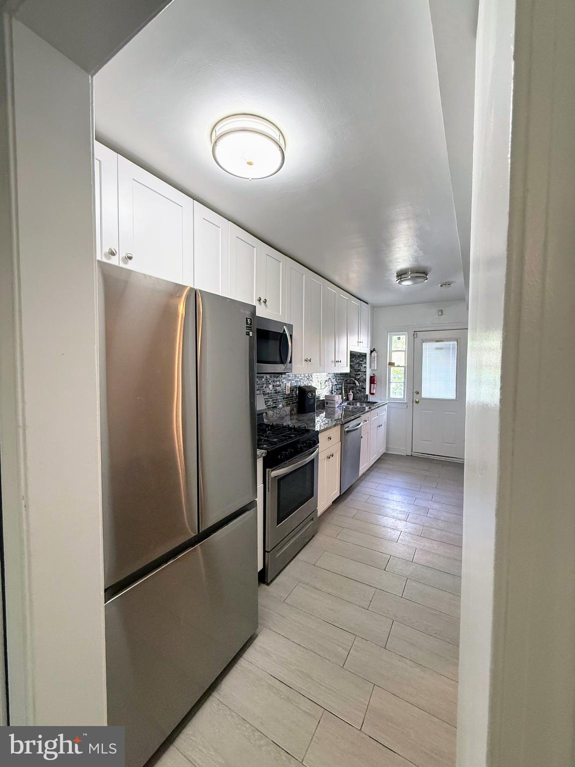 1714 E Street Northeast Washington, DC 20002 - Photo 3 of 30 a kitchen with stainless steel appliances granite countertop a refrigerator a stove a sink and a microwave