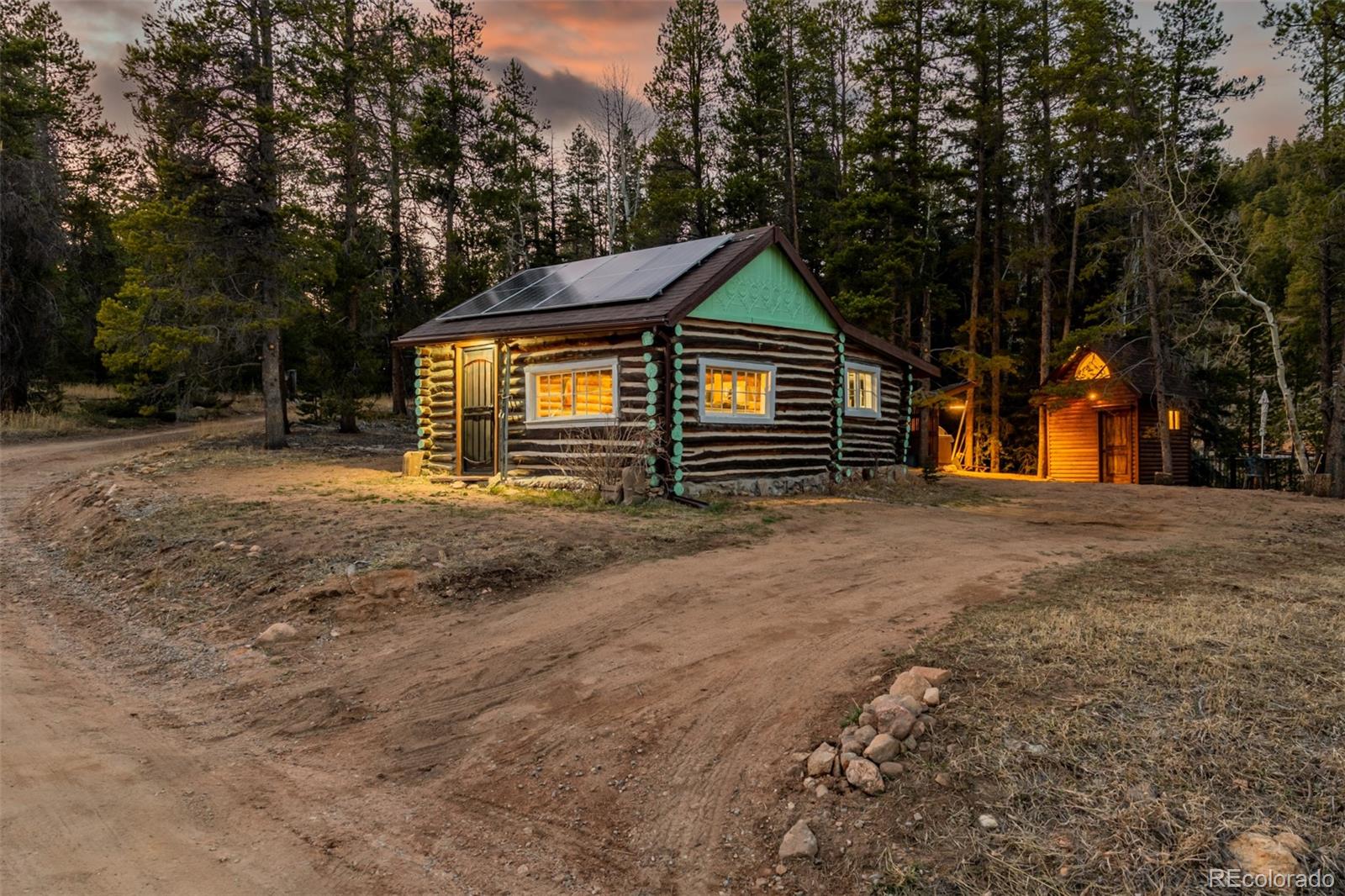 9719 Beaver Pond Conifer, CO 80433 - Photo 2 of 50 a front view of a house with a yard and garage