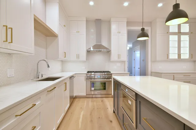 a kitchen with stainless steel appliances granite countertop a sink a stove and a refrigerator