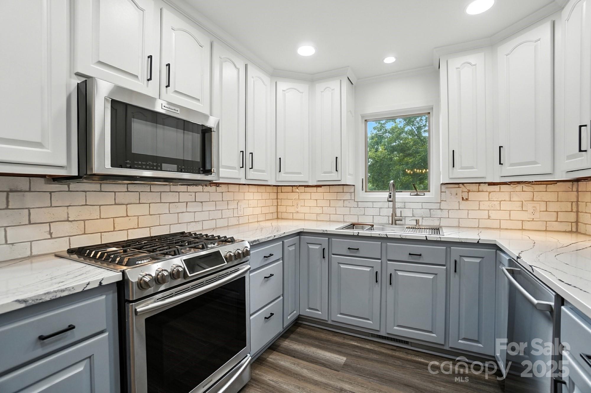 256 Johnson Dairy Road Davidson, NC 28036 - Photo 17 of 44 a kitchen with granite countertop a stove sink and cabinets