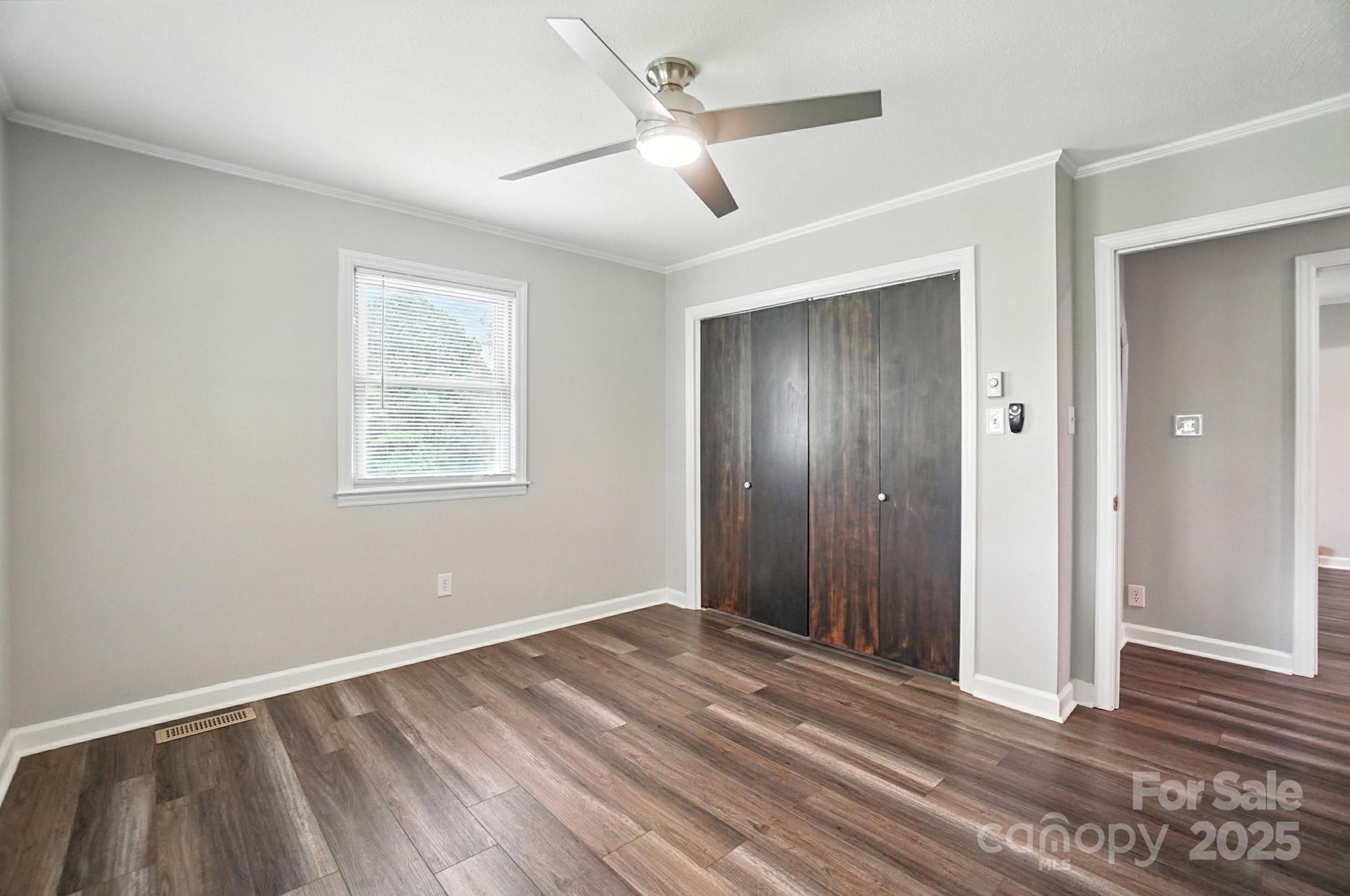 256 Johnson Dairy Road Davidson, NC 28036 - Photo 23 of 44 a view of an empty room with wooden floor and a ceiling fan
