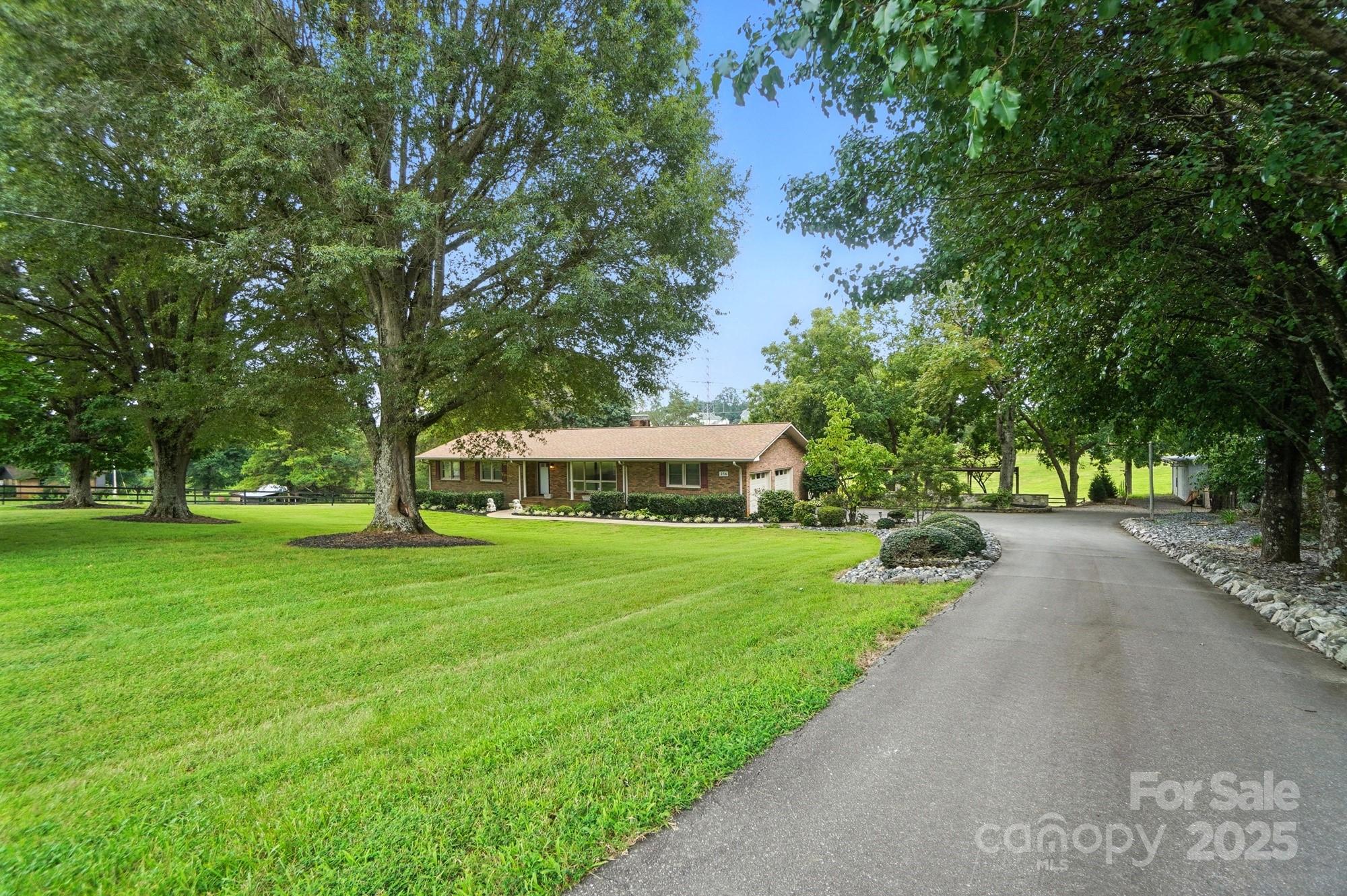 256 Johnson Dairy Road Davidson, NC 28036 - Photo 3 of 44 a front view of a house with a yard and trees