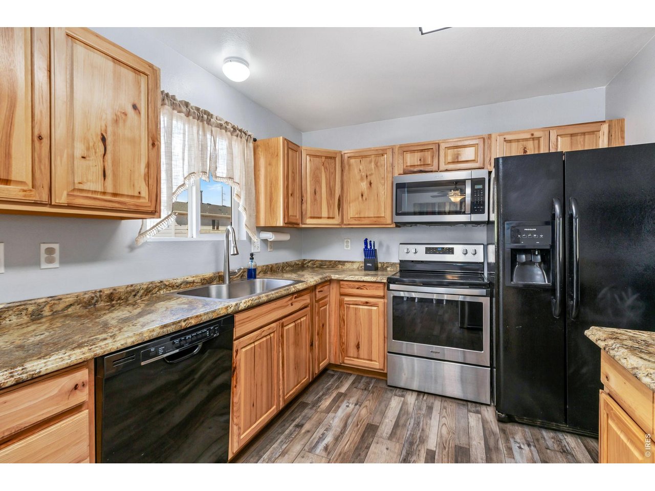 233 East 19th Street Road Greeley, CO 80631 - Photo 9 of 22 a kitchen with stainless steel appliances granite countertop a refrigerator and a sink