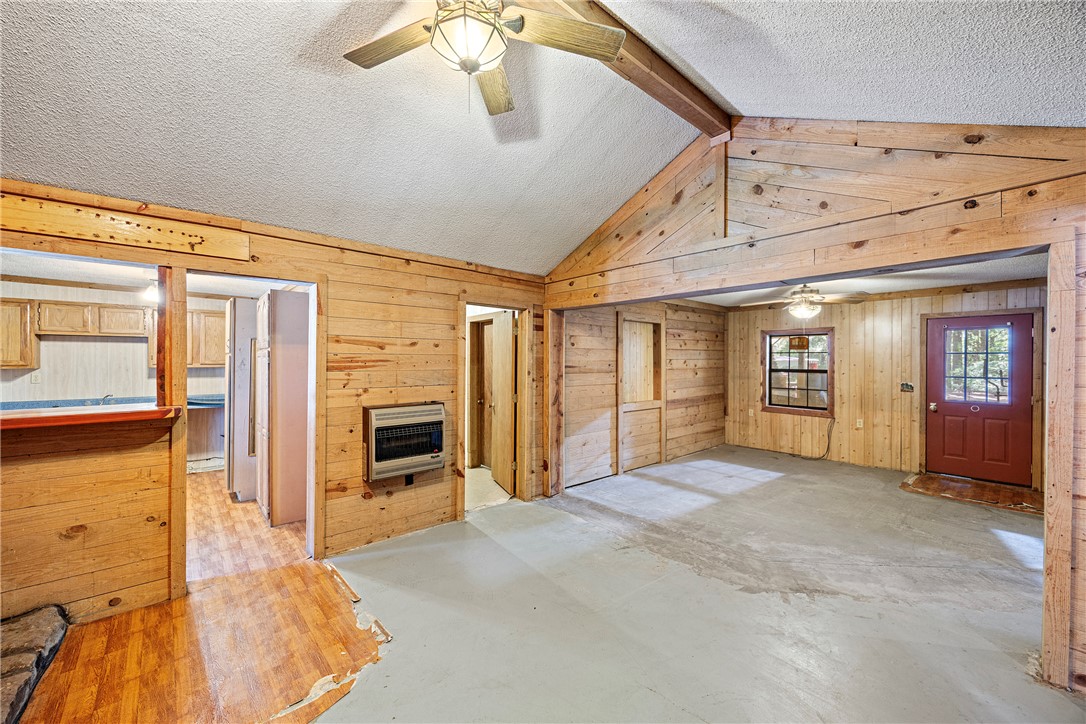 655 Charton Road Morrilton, AR 72110 - Photo 40 of 49 Spacious interior featuring wood paneling, vaulted ceilings with exposed beams, and a ceiling fan